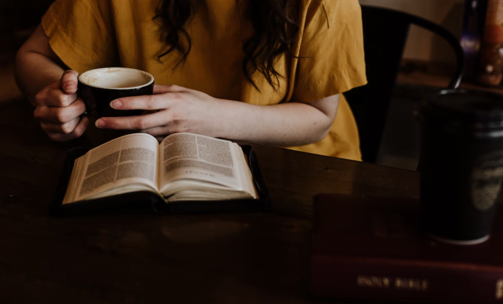 local Orlando author reading a book with a cup of coffee in her hand