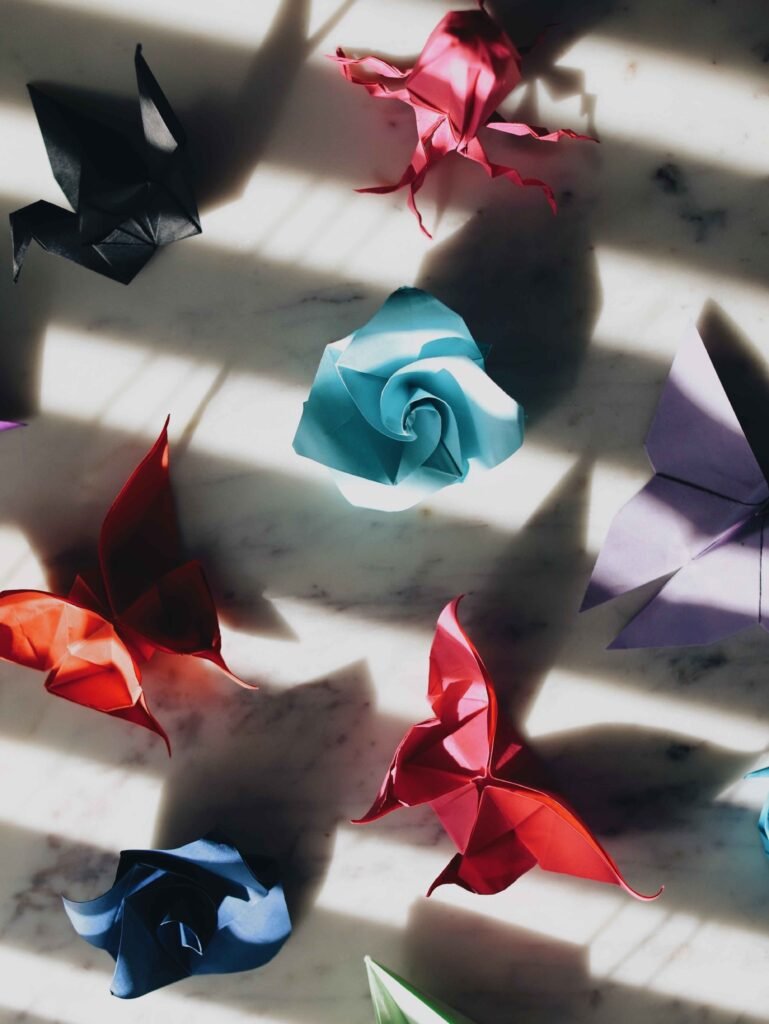 different colors of origami folded to look like a butterflies and flowers