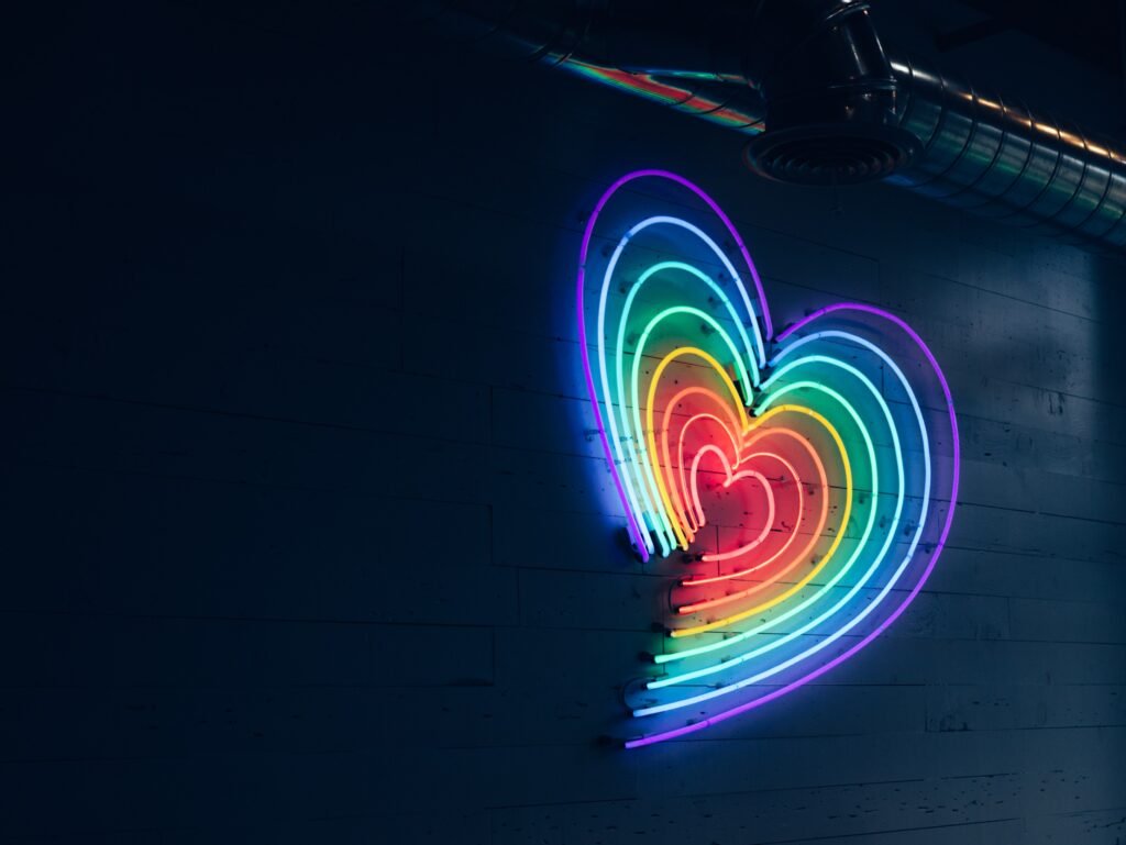 neon multi colored heart on a wall