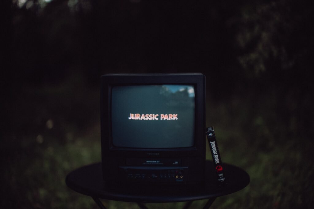 old TV and VHS combo with the move Jurassic Park starting to play on it.