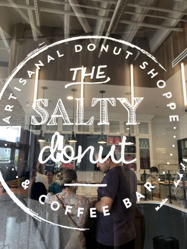 the sign on the glass of the front door at  the salty donut