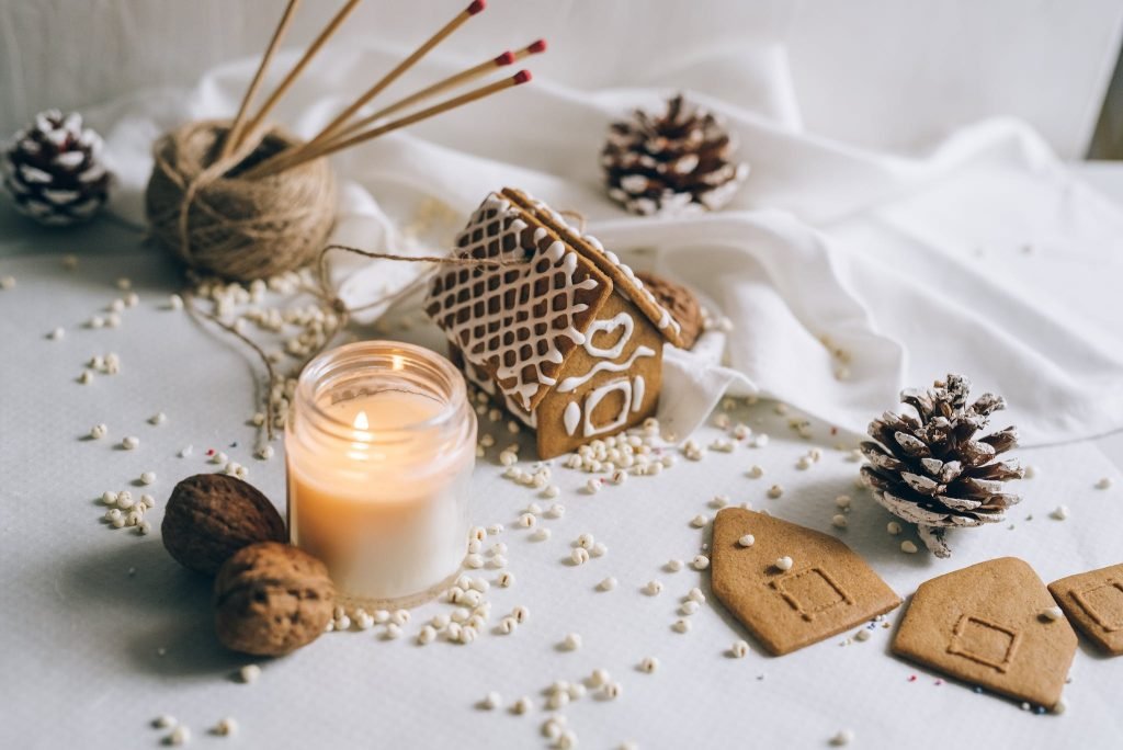 A Gingerbread House Beside a Lit candle