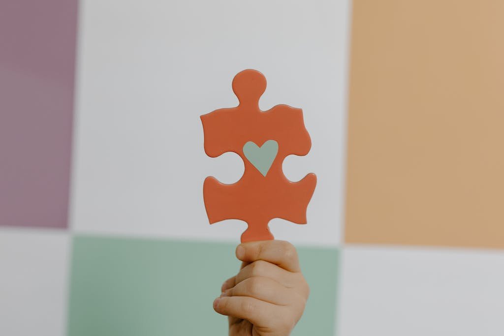 Person Holding Orange Puzzle Piece