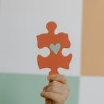 Person Holding Orange Puzzle Piece