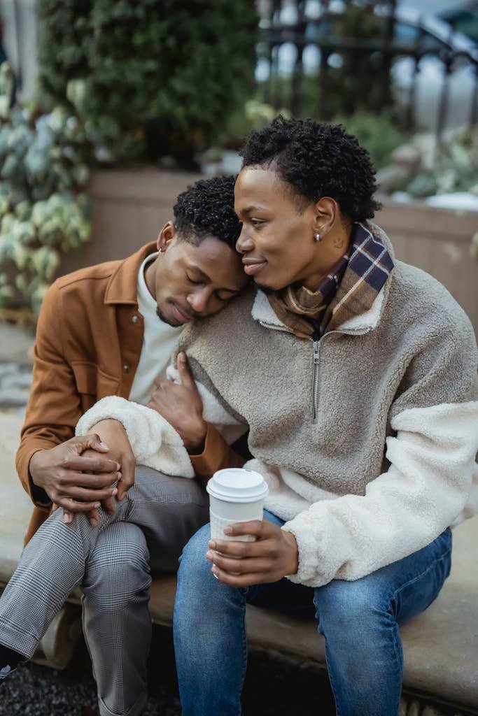 Romantic black gays with coffee on street