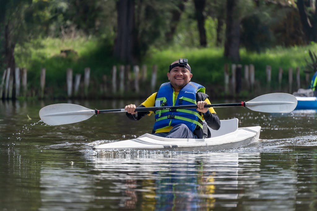 A man in a life jacket paddles a kayak