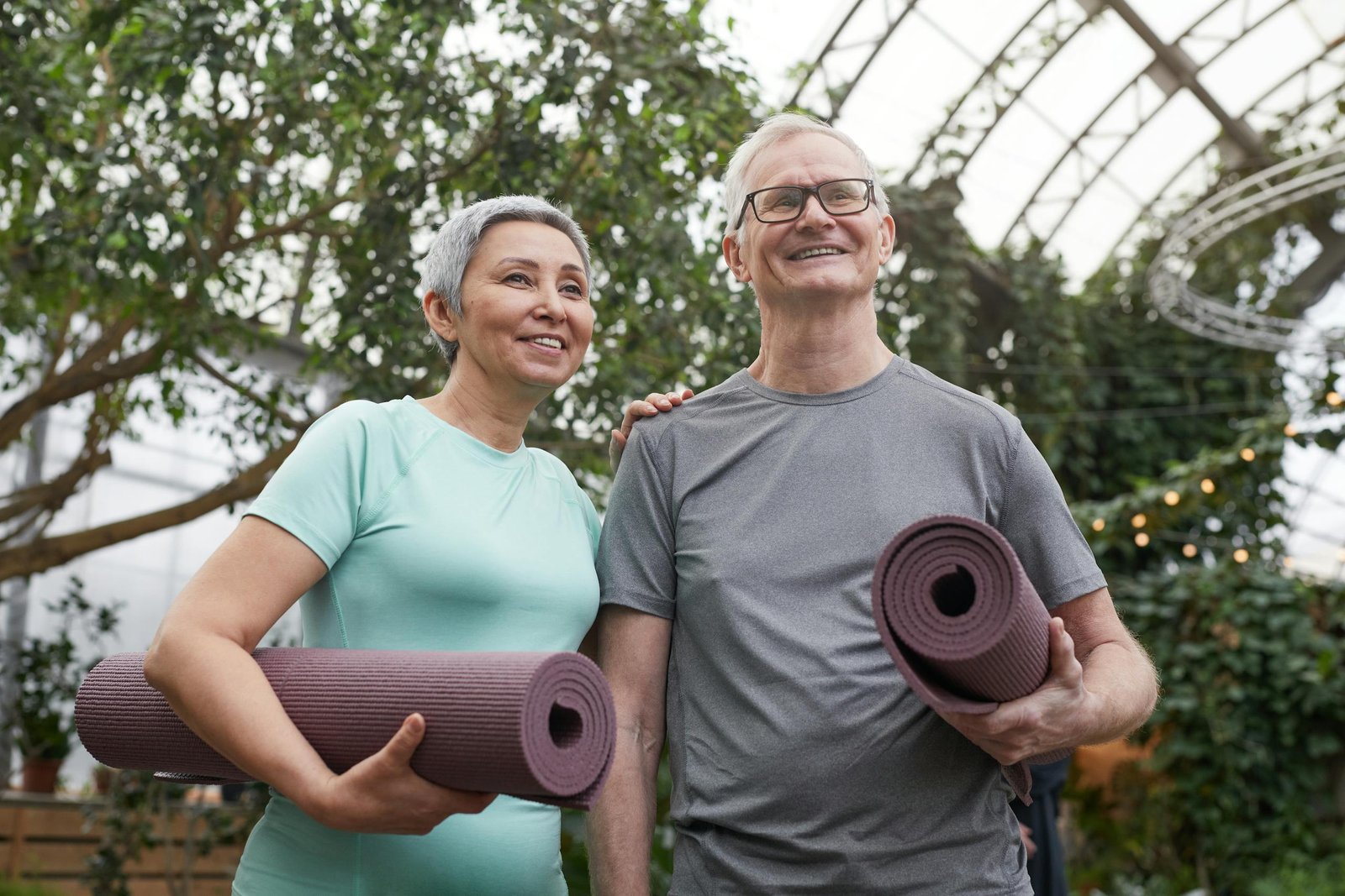 Couple Smiling While Holding Yoga Mats