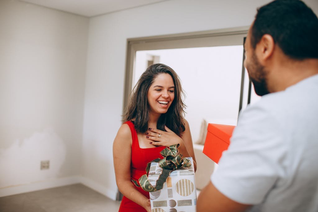 A man giving a woman a gift in a room