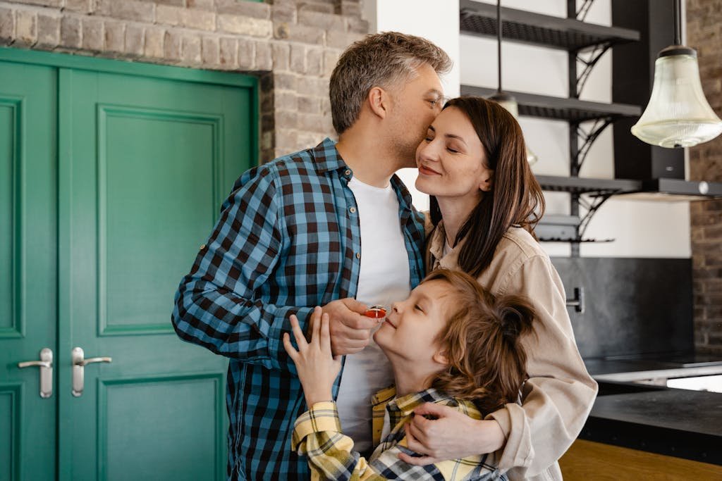 A loving family shares a group hug in their modern kitchen, showcasing warmth and togetherness.