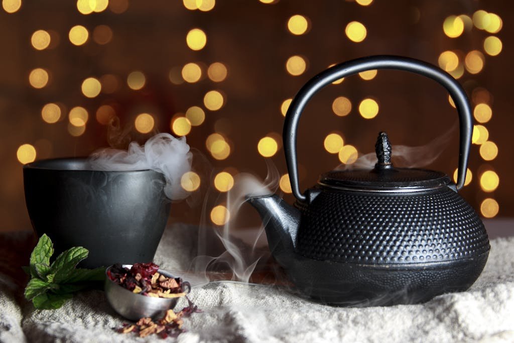 A serene still life of a black teapot and teacup with herbal tea, exuding warmth and tradition.