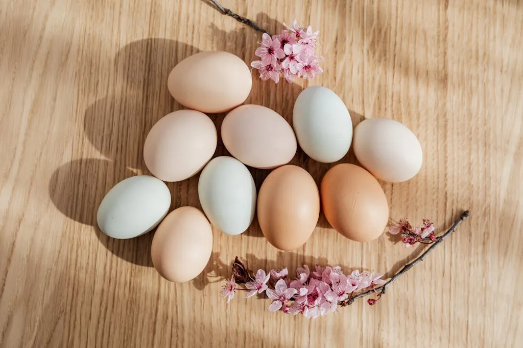 Pastel colored eggs with cherry blossoms on wood, perfect Easter decoration concept.