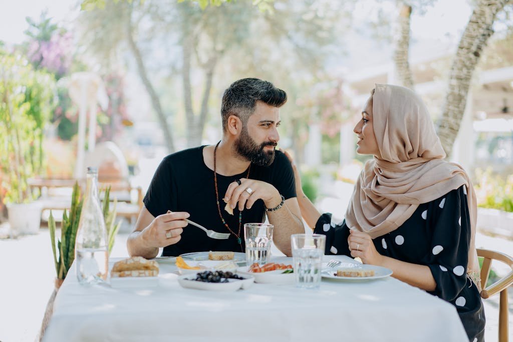 A couple enjoys a meal at an outdoor cafe, creating a warm and inviting scene.