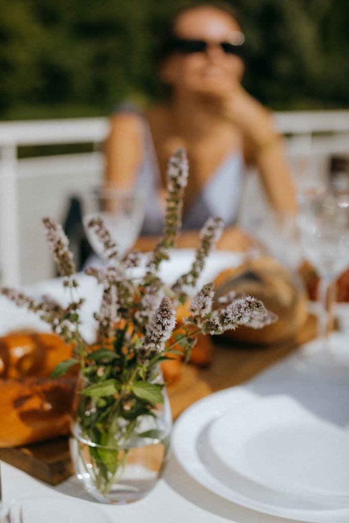 A scenic outdoor dining setting with a focus on a beautiful floral arrangement.