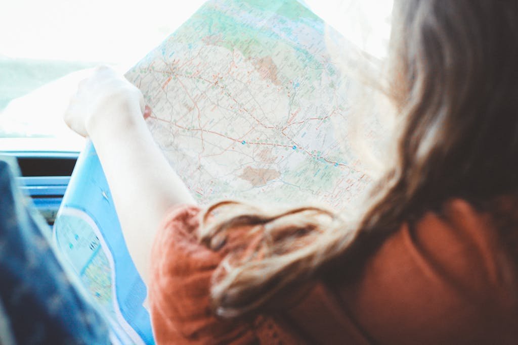 A young woman studies a map, planning her road trip adventure.