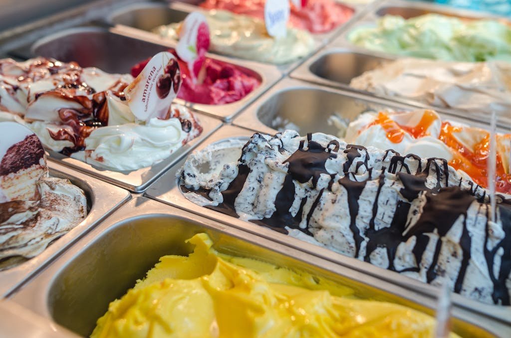 Close-up of various gelato flavors in a parlor display, perfect for dessert enthusiasts.