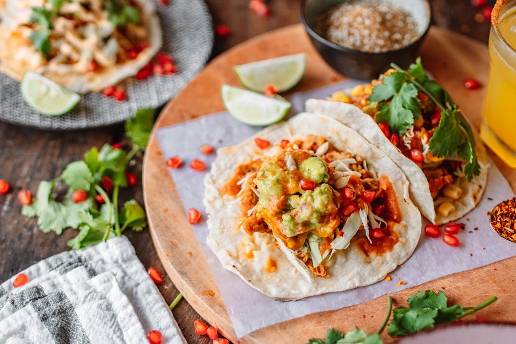 Delicious Mexican tacos topped with fresh guacamole and lime, perfect for a vibrant and flavorful meal.