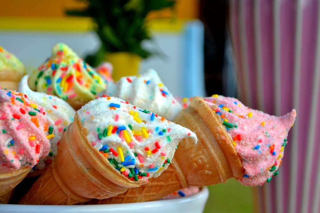 Vibrant ice cream cones topped with colorful sprinkles, perfect for summer treats.