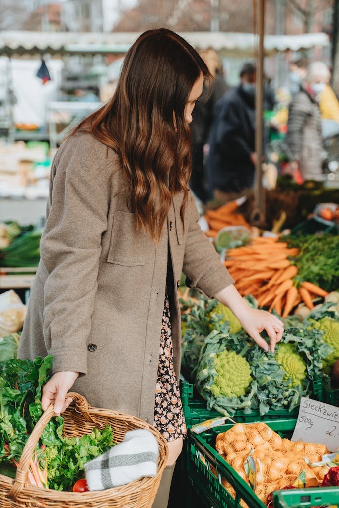 Woman selects fresh vegetables at an outdoor market in Erfurt, Germany, emphasizing a healthy lifestyle.