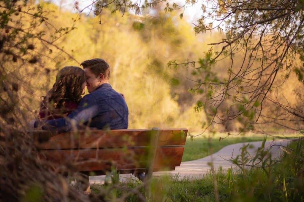 couple on a park bench while on a bird watching date