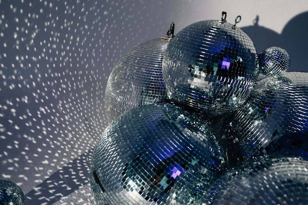 16 Epic At-Home Date Night Ideas That'll Make You Cancel Your Dinner Reservations 7 Cluster of disco balls casting shimmering reflections, embodying retro and festive vibes.